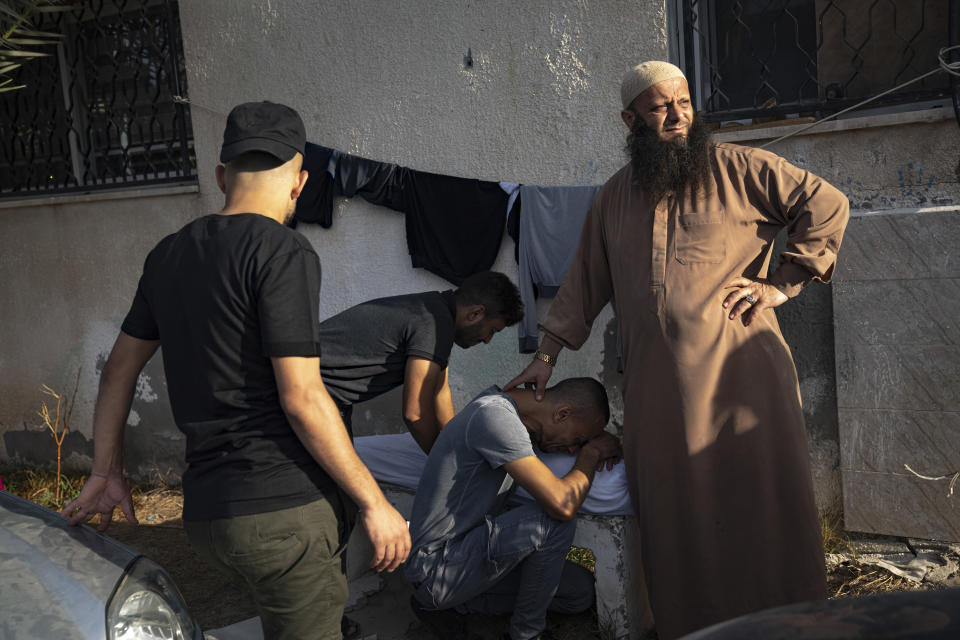 Palestinians mourn relatives at a morgue in Khan Younis on Tuesday.