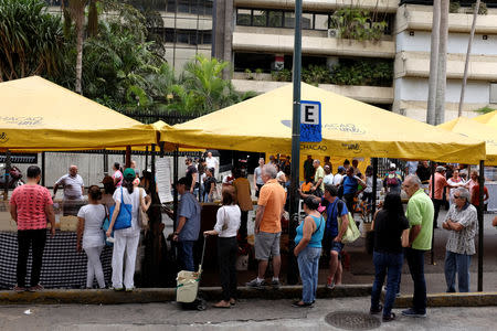 People wait in a queue to buy food in a street market in Caracas, Venezuela August 18, 2018. REUTERS/Marco Bello