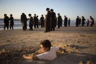 <p>A boy is covered in sand as ultra-Orthodox Jewish men of the Vizhnitz Hassidic sect pray at Mediterranean Sea shore as they participate in a Tashlich ceremony, in Herzeliya, Israel, Thursday, Sept. 28, 2017. Tashlich, which means “to cast away” in Hebrew, is the practice in which Jews go to a large flowing body of water and symbolically “throw away” their sins by throwing a piece of bread, or similar food, into the water before the Jewish holiday of Yom Kippur, which starts at sundown Friday. (Photo: Ariel Schalit/AP) </p>