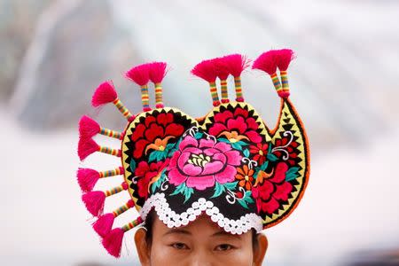 A woman wears traditional headgear during a session of the Yunnan province on the second day of the 19th National Congress of the Communist Party of China at the Great Hall of the People in Beijing, October 19, 2017. REUTERS/Thomas Peter