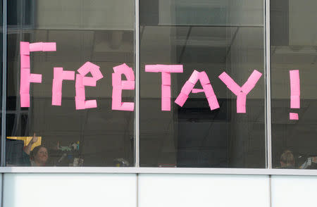 An office worker gives a thumbs up after placing a sign in the windows of her building across the street from Denver Federal Court where the Taylor Swift groping trial jury selection resumes in Denver. REUTERS/Rick Wilking