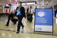 A flight crew walk through the terminal at Sydney Airport, Monday, Nov. 29, 2021. Authorities in Australia said Sunday, Nov. 28, 2021, that two travelers who arrived in Sydney from Africa became the first in the country to test positive for the new variant of the coronavirus, omicron. (AP Photo/Mark Baker)