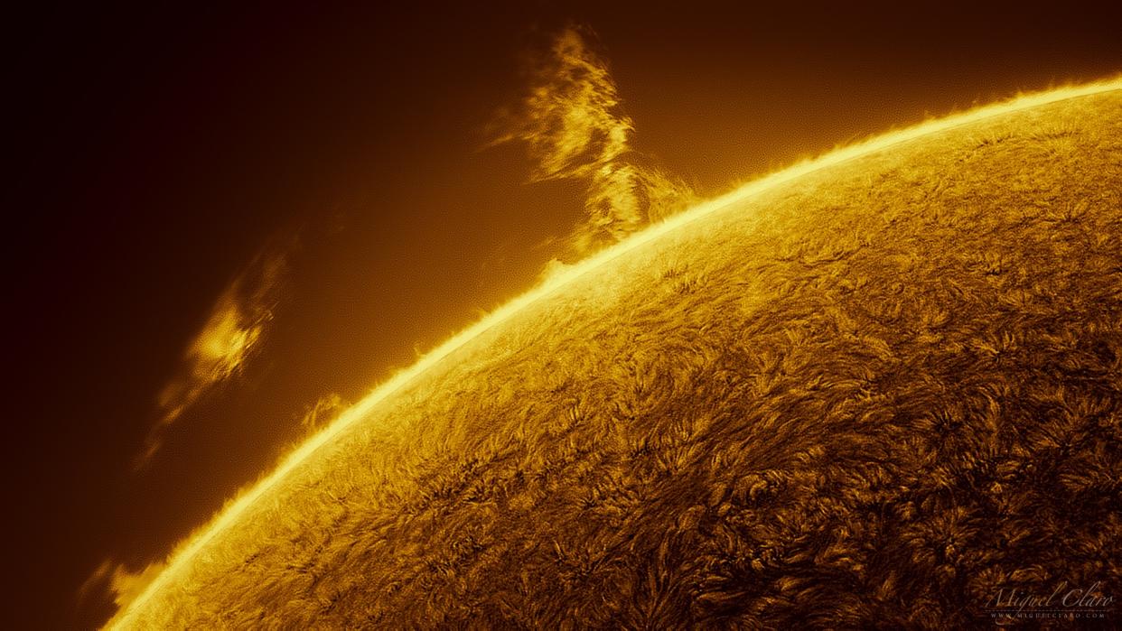  A close-up image of the sun showing a giant tower of fiery plasma erupting from its surface. 