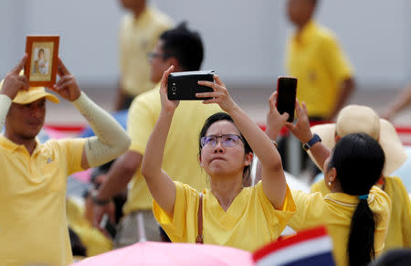 A woman takes pictures outside the balcony of Suddhaisavarya Prasad Hall at the Grand Palace where of King Maha Vajiralongkorn will grant a public audience to receive the good wishes of the people in Bangkok, Thailand May 6, 2019. REUTERS/Jorge Silva