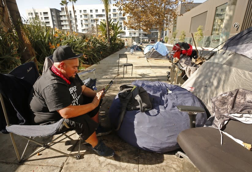 LOS ANGELES, CA - NOVEMBER 24: P.J. Butters, 44, who's lives in his tent on Homewood Avenue in Hollywood enjoys the quiet location with homeless neighbors that are nearly surrounded by new apartment and commercial development. Covid-19 restrictions has created challenges for homeless people seeking indoor spaces where they used to find respite. They can no longer go into libraries or cafes to sit inside and charge phones and get on the Internet and stay warm during the day. Hollywood on Tuesday, Nov. 24, 2020 in Los Angeles, CA. (Al Seib / Los Angeles Times