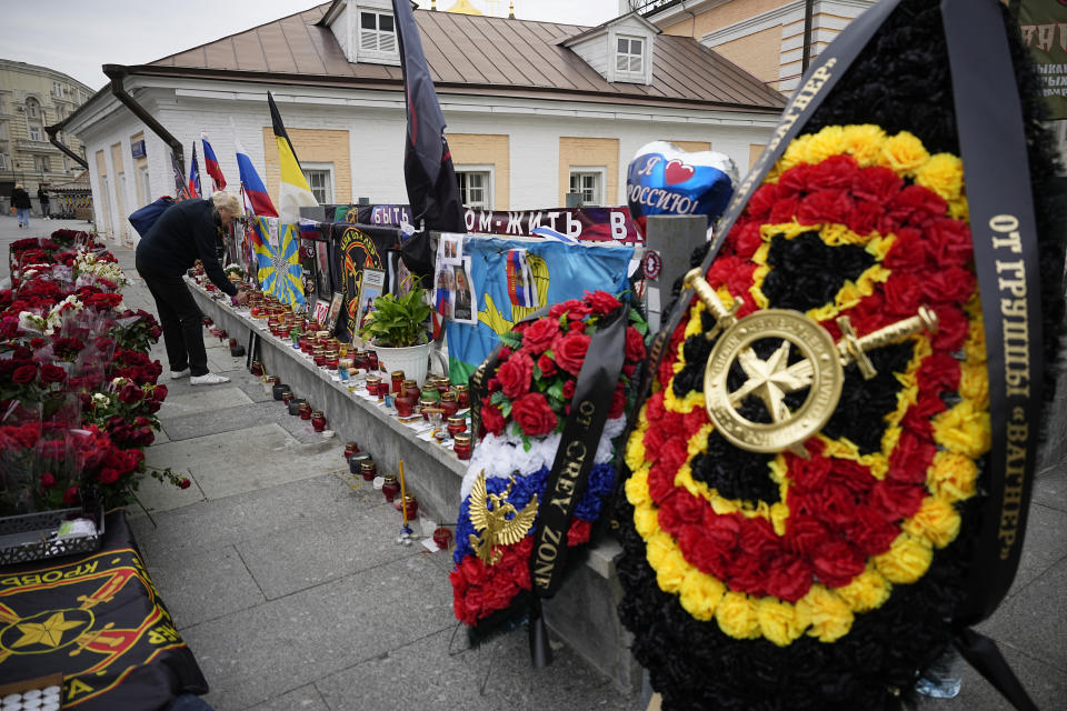 A woman lights a candle at an informal street memorial for Wagner Group's members killed in a plane crash, near the Kremlin in Moscow, Russia, Tuesday, Aug. 29, 2023. Prigozhin was aboard a plane that crashed north of Moscow killing all 10 people on board. Russia's Investigative Committee said forensic and genetic testing identified all 10 bodies recovered from the crash, and the identities "conform with the manifest." (AP Photo/Alexander Zemlianichenko)