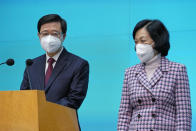 Hong Kong Chief Executive John Lee, left, and convener of the Executive Council Regina Ip attend a news conference in Hong Kong, Tuesday, July 5, 2022. Lee said Tuesday in his first news conference since taking the reins that he will work towards legislating easing restrictions for travelers, but that it must be balanced with limiting the spread of the coronavirus so as not to overwhelm the healthcare system. (AP Photo/Kin Cheung)