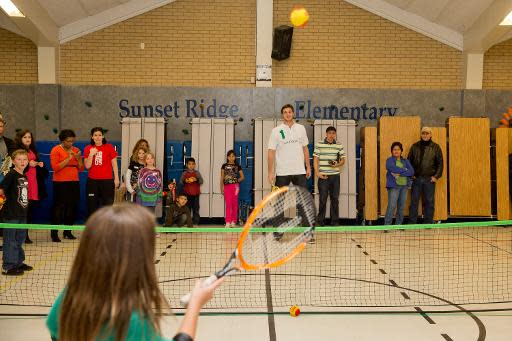 Danilo Gallinari, #8 de los Denver Nuggets de la liga NBA de baloncesto y embajador de la organización Laureus, juega al tenis con una niña en el marco del Lanzamiento del Proyecto Denver para apoyar un programa social deportivo en Westminster, Colorado, el 12 de noviembre de 2013. (GETTY IMAGES NORTH AMERICA/AFP | Justin Edmonds)