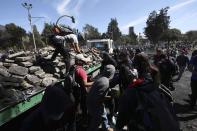 Volunteers dismantle a barricade in a major cleanup effort in the aftermath of violent protests against the government, in Quito, Ecuador, Monday, Oct. 14, 2019. Ecuador celebrated a deal President Lenín Moreno and indigenous leaders struck late Sunday to cancel a disputed austerity package and end nearly two weeks of protests that have paralyzed the economy and left seven dead. (AP Photo/Fernando Vergara)