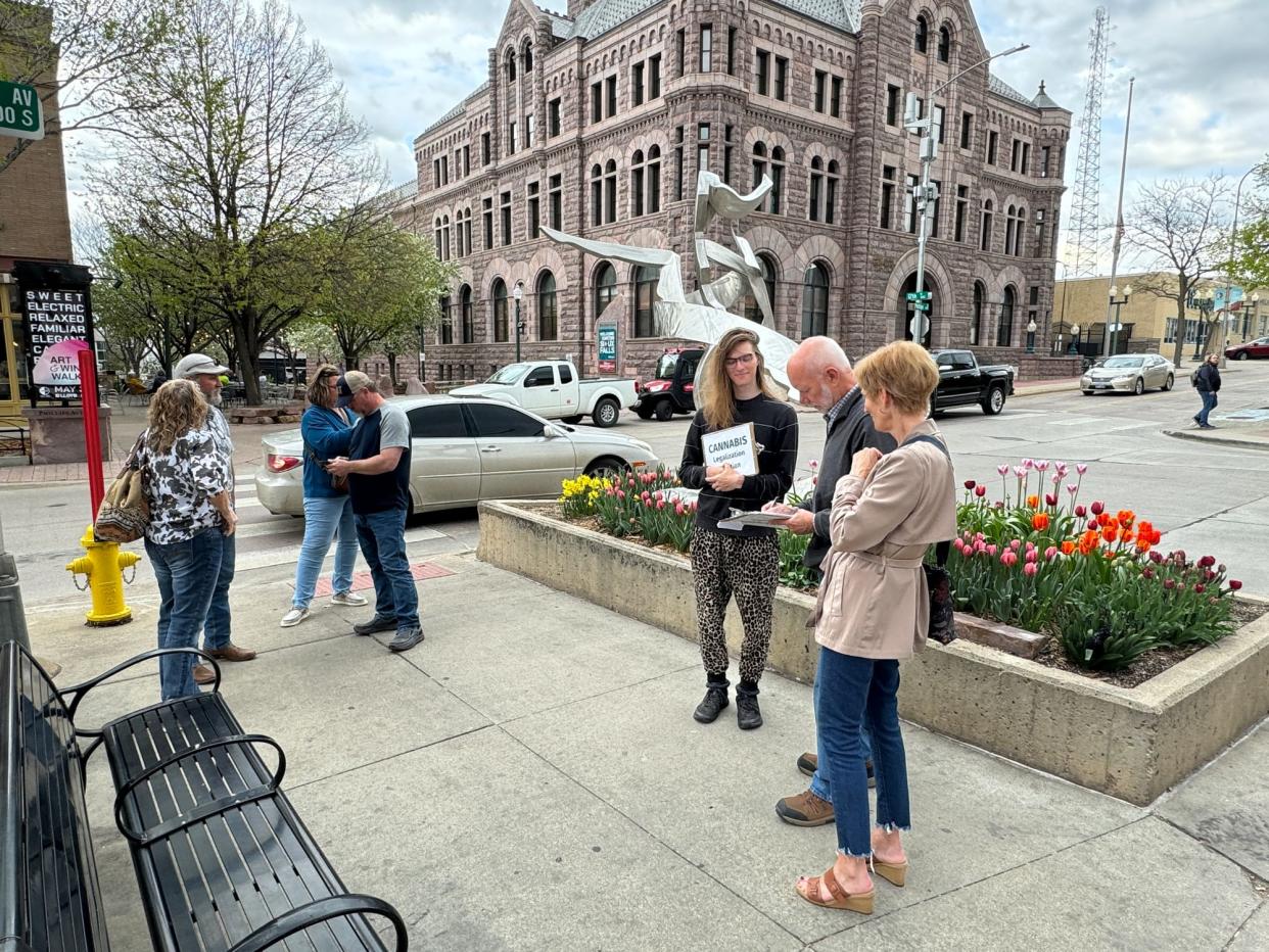 Ivy Cool of Sioux Falls (third from right) gathers signatures for a petition to legalize recreational marijuana while stationed at the corner of 12th Street and Phillips Avenue in downtown Sioux Falls on May 3, 2024.
