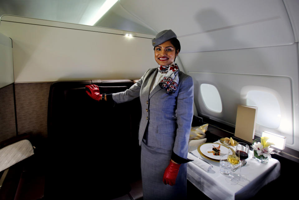 An Etihad Airways official poses for a photograph inside the 125-square-foot (11.61-square-meter) area that includes a “living room” partitioned off from the first-class aisle that includes leather seating, chilled minibar and a 32-inch flat-screen TV, at a training facility in Abu Dhabi, United Arab Emirates, Sunday, May 4, 2014. Etihad Airways, a fast-growing Mideast carrier, laid out plans Sunday to offer passengers who find first-class seats a bit too tight a miniature suite featuring a closed-off bedroom, private bathroom and a dedicated butler. (AP Photo/Kamran Jebreili)