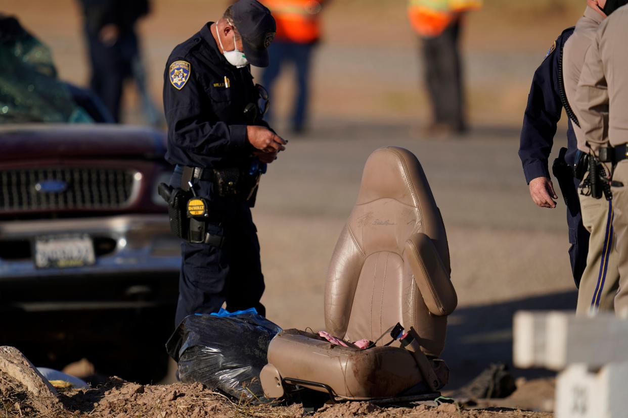 Law enforcement officers sort evidence and debris at the scene of a deadly crash in Holtville, Calif. on Tuesday, March 2, 2021.