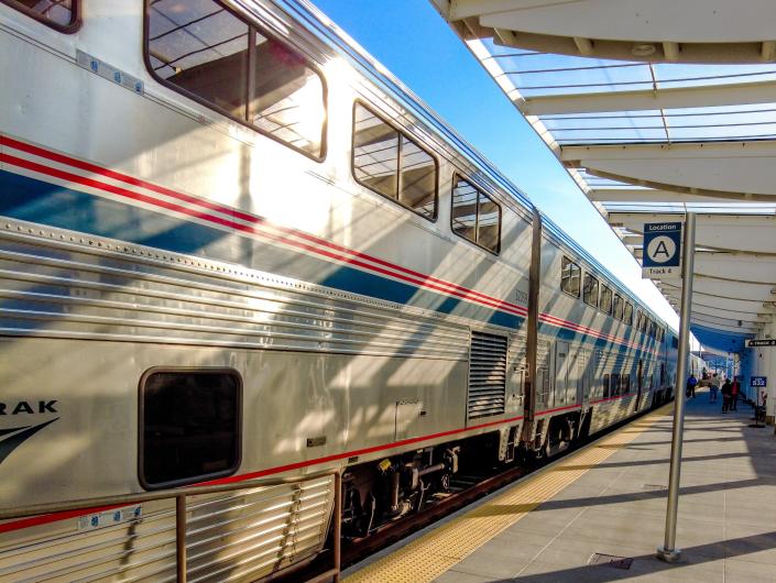 The silver, blue, and red Amtrak train at the concrete platform
