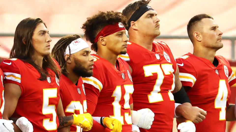 The Kansas City Chiefs are pictured with arms linked.