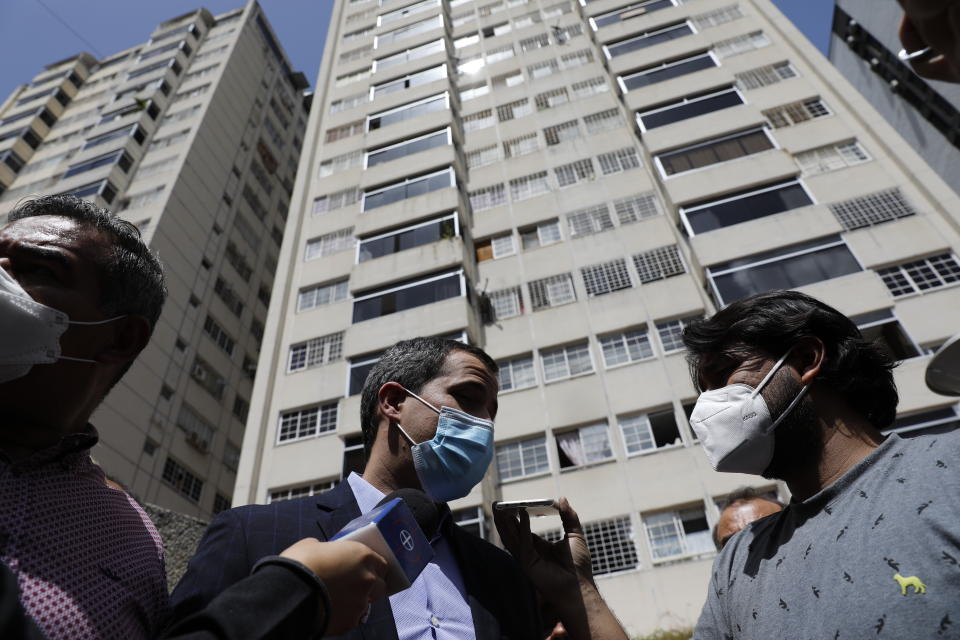 Opposition leader Juan Guaido speaks to the press at his residential building in Caracas, Venezuela, Monday, July 12, 2021. Guaido said security forces threatened his driver when he and his driver arrived home Monday. (AP Photo/Ariana Cubillos)