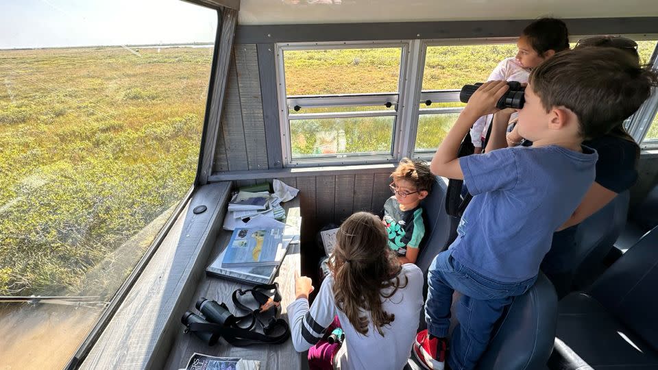 Bring your binoculars! Young Tundra Buggy passengers with Frontier North Adventures scout for wildlife during a stop in the Churchill Wildlife Management Area. - Terry Ward