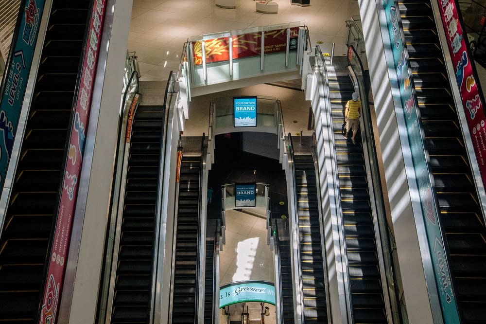 A visitor takes the escalator at the NU Sentral shopping mall in Kuala Lumpur June 2, 2021. — Picture by Firdaus Latif