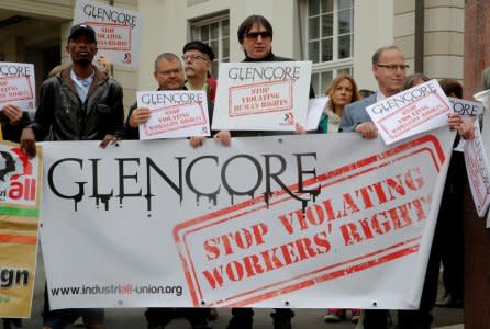 FILE PHOTO: Protesters display a banner and posters in front of the venue of commodities trader Glencore's  annual shareholder meeting in Zug, Switzerland May 2, 2018.  REUTERS/Arnd Wiegmann