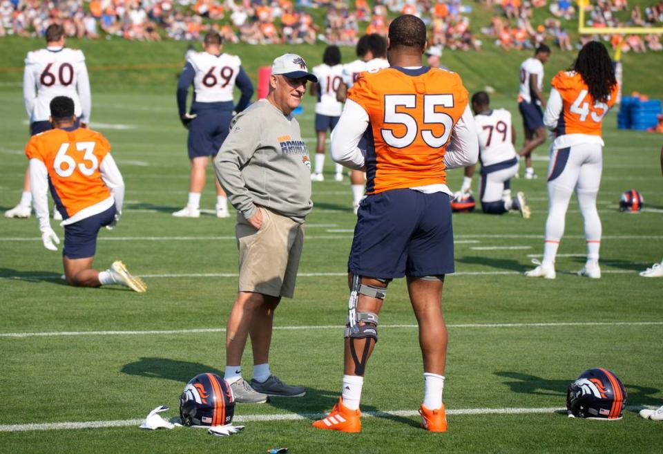 Denver Broncos head coach Vic Fangio, left, chats with outside linebacker Bradley Chubb as he prepares to stretch before drills at an NFL football training camp Monday, Aug. 2, 2021, at team headquarters in Englewood, Colo. (AP Photo/David Zalubowski)