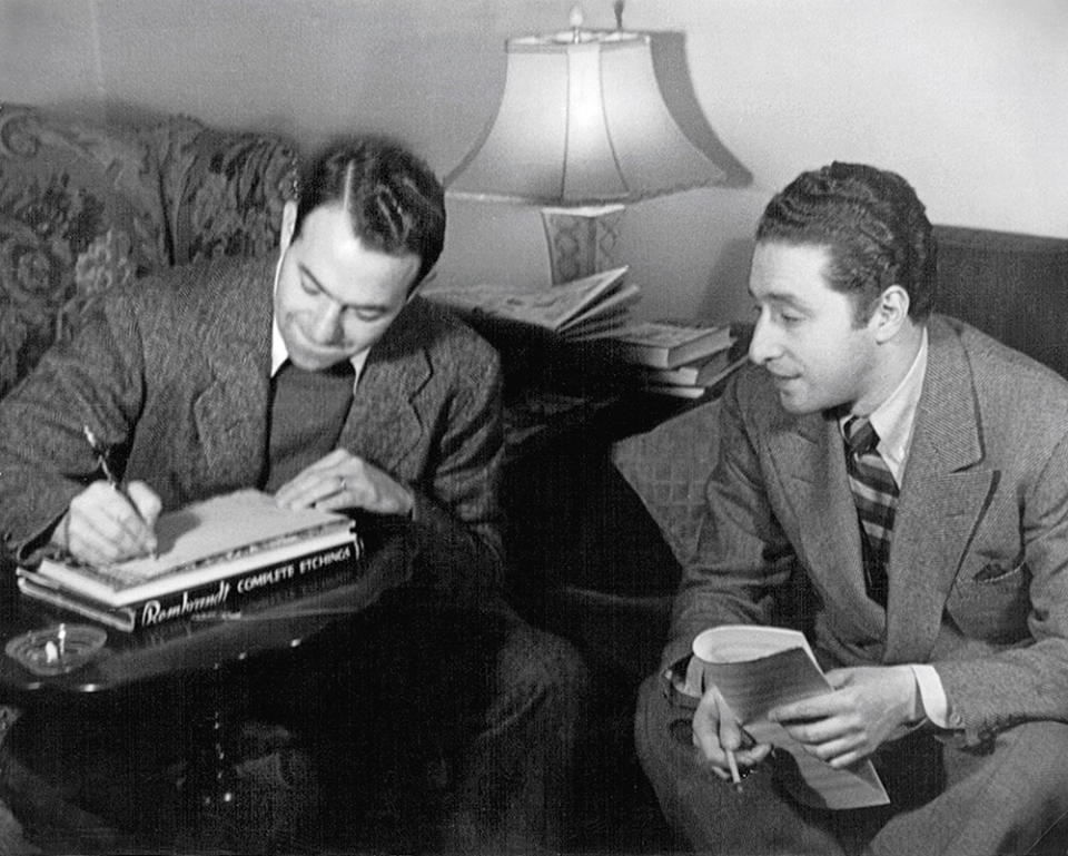 Lyricist Yip Harburg (writing) and composer Harold Arlen, the team behind all the songs in Wizard of Oz, including “Over the Rainbow.”