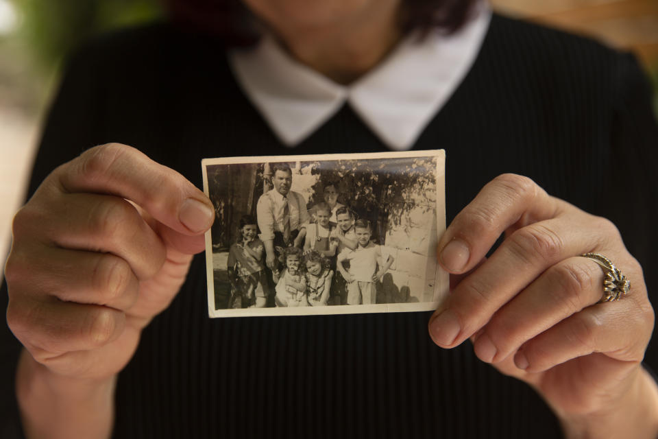 Samira Dajani holds a photo of her family in 1956 after they moved into their home in the Sheikh Jarrah neighborhood of east Jerusalem, Sunday, May 9, 2021. The Dajanis are one of several Palestinian families facing imminent eviction in the Sheikh Jarrah neighborhood of east Jerusalem. The families' plight has ignited weeks of demonstrations and clashes in recent days between protesters and Israeli police. (AP Photo/Maya Alleruzzo)