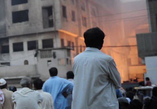 Anxious relatives and local residents watch the rescue operation at a garment factory in Karachi on Wednesday. A huge fire at a garment factory in Pakistan's largest city of Karachi has killed at least 240 people, Karachi city's police chief Iqbal Mehmood, told AFP