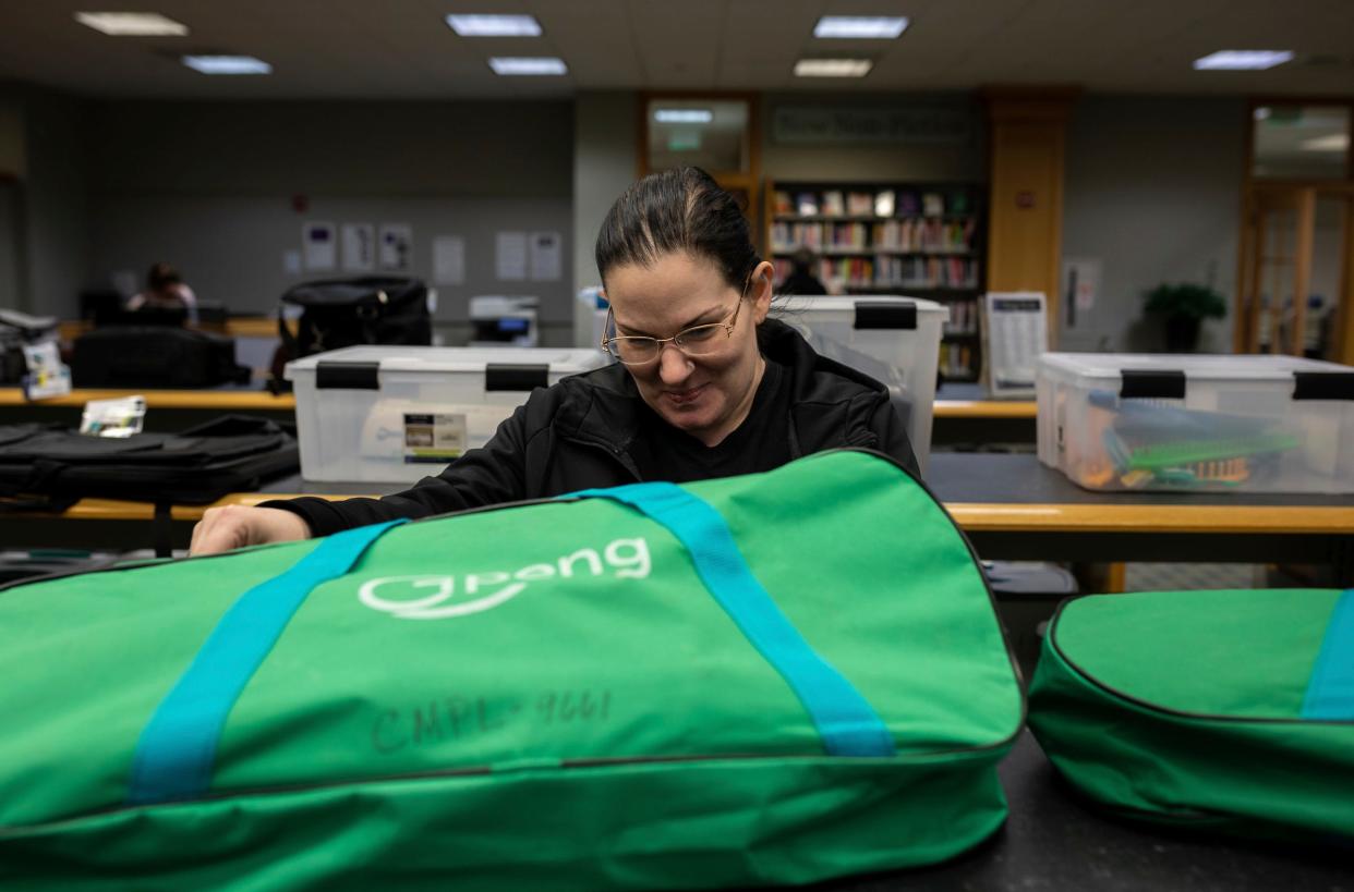 Rachel Al-Zubaidi smiles as she looks through the Things to Go section inside the Clinton-Macomb Public Library in Clinton Township on Tuesday, Feb. 13, 2024.