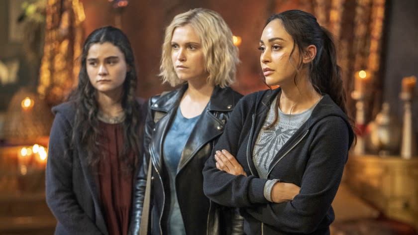 The 100 -- The CW TV Series, The 100 -- "Blood Giant" -- Image Number: HU711B_0434r.jpg -- Pictured (L-R): Lola Flanery as Madi, Eliza Taylor as Clarke and Lindsey Morgan as Raven -- Photo: Colin Bentley/The CW -- © 2020 The CW Network, LLC. All rights reserved. "The 100" on The CW.