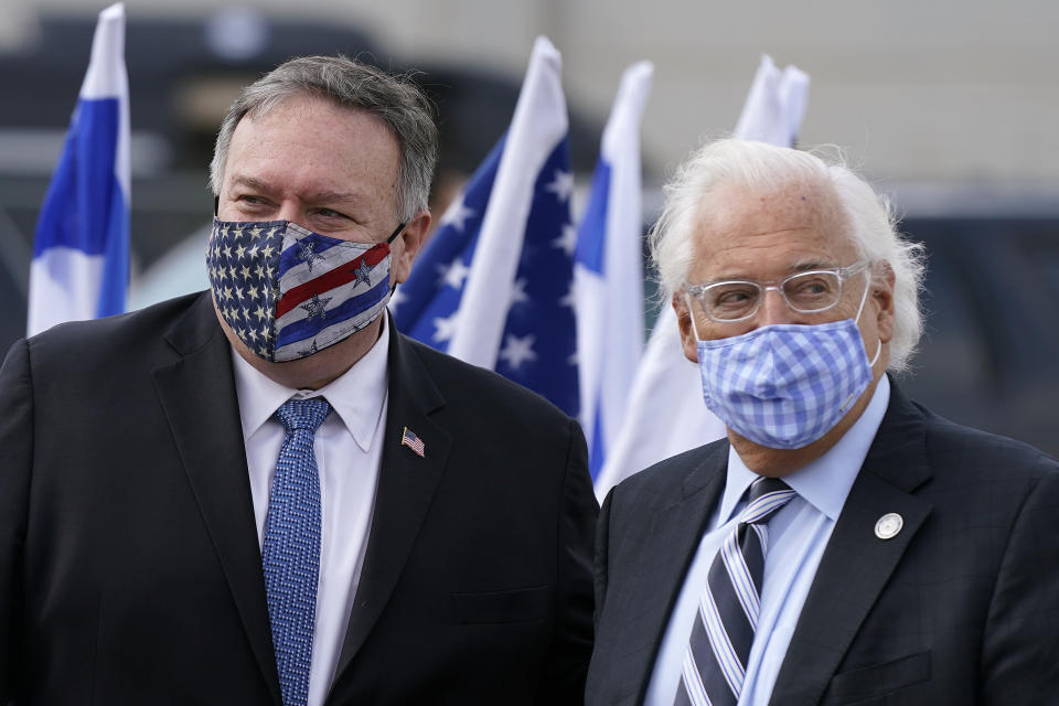 Secretary of State Mike Pompeo, left, walks with U.S. Ambassador to Israel David Friedman as he prepares to board a plane at Ben Gurion Airport in Tel Aviv, Friday, Nov. 20, 2020. Pompeo is en route to the United Arab Emirates. (AP Photo/Patrick Semansky, Pool)