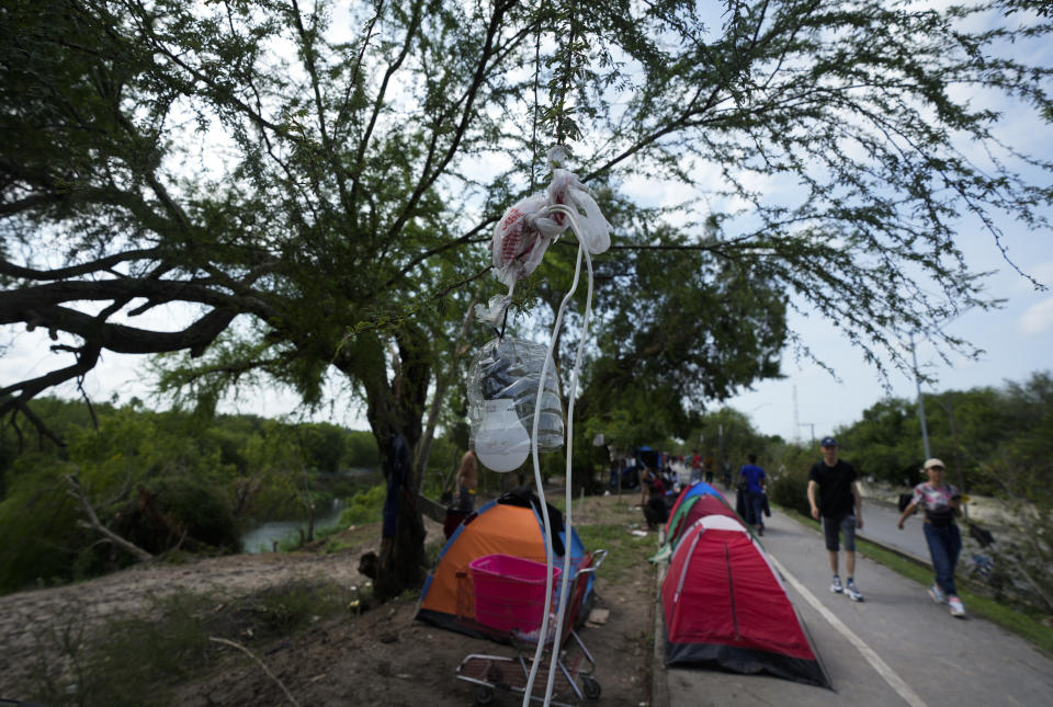 Migrants get electricity from an illegal connection for their tents on the bank of the Rio Grande in Matamoros, Mexico, Sunday, May 14, 2023. As the U.S. ended its pandemic-era immigration restrictions, migrants are adapting to new asylum rules and legal pathways meant to discourage illegal crossings. (AP Photo/Fernando Llano)