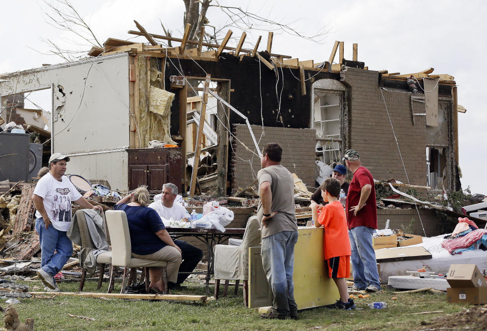 Adam Danner, third from left, and his wife, Tiffani, second from left, talk with friends as they take a break from salvaging items from the Danners' home Tuesday, April 29, 2014, in Fayetteville, Tenn. Around 50 tornadoes ravaged the South Monday, according to the National Oceanic and Atmospheric Administration's Storm Prediction Center. (AP Photo/Mark Humphrey)