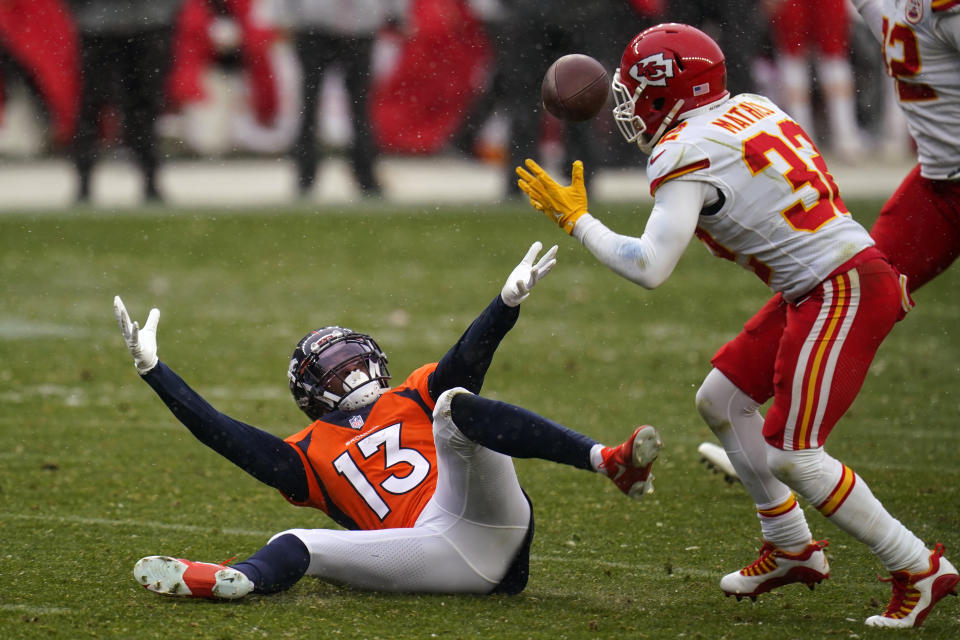 Denver Broncos wide receiver K.J. Hamler (13) falls as Kansas City Chiefs strong safety Tyrann Mathieu intercepts a pass during the second half of an NFL football game Sunday, Oct. 25, 2020, in Denver. (AP Photo/Jack Dempsey)