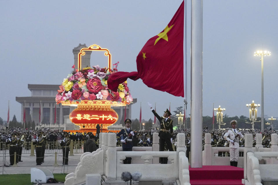 In this photo released by Xinhua News Agency, a member of the Chinese honor guard unfurls the Chinese national flag during a flag raising ceremony to mark the 73rd anniversary of the founding of the People's Republic of China held at the Tiananmen Square in Beijing on Saturday, Oct. 1, 2022. (Ju Huanzong/Xinhua via AP)