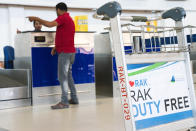 A man speaks to a check-in counter employee at the Ras al-Khaimah International Airport in Ras al-Khaimah, United Arab Emirates, Wednesday, Oct. 23, 2019. India's low-cost airline SpiceJet announced plans Wednesday to build its first international hub in the United Arab Emirates, offering a pledge of support to Boeing Co. by saying it would use now-grounded 737 MAX aircraft in the operation once regulators approve the planes for flight. (AP Photo/Jon Gambrell)
