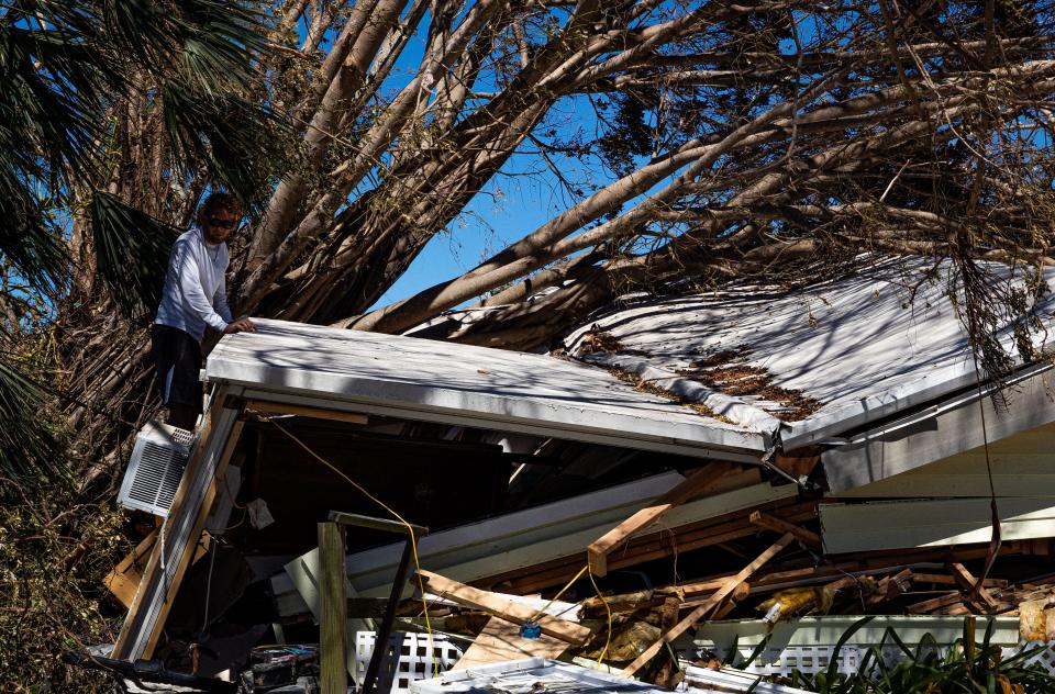 A man inspects damage of his friends home following Hurricane Ian on Oct. 2, 2022. 