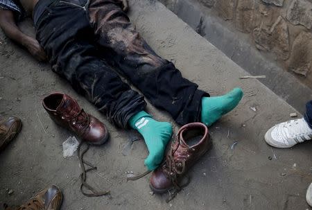 Onlookers gather around the body of man in the streets of Bujumbura's Niyakabiga district on presidential election day in Burundi, July 21, 2015. REUTERS/Mike Hutchings