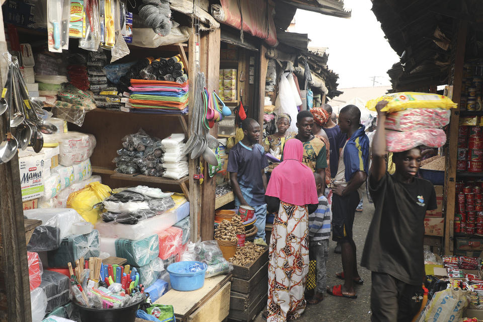 Pedestrian shop for food items at the Mile 12 Market in Lagos, Nigeria, Friday, Feb. 16, 2024. Nigerians are facing one of the West African nation's worst economic crises in as many years triggered by a surging inflation rate which follows monetary policies that have dipped the local currency to an all-time low against the dollar, provoking anger and protests across the country. (AP Photo/Mansur Ibrahim)