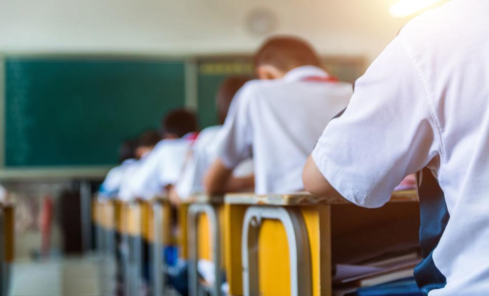 rear view of middle school students studying in classroom