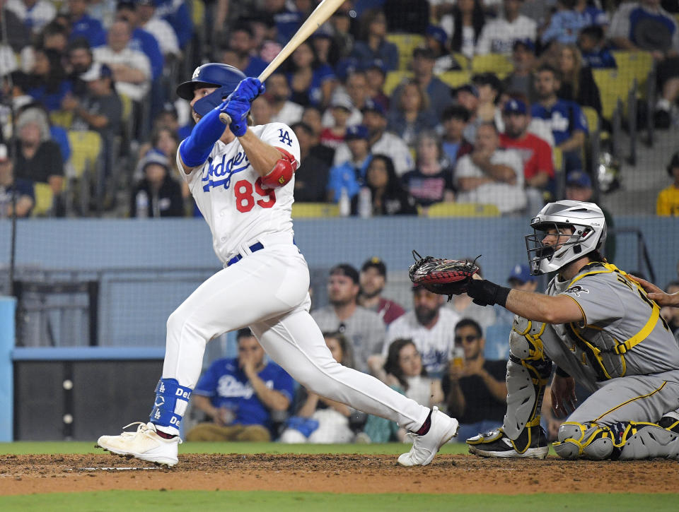 FILE - Los Angeles Dodgers' Jonny Deluca, left, hits a solo home run as Pittsburgh Pirates catcher Austin Hedges, right, watches during the eighth inning of a baseball game July 4, 2023, in Los Angeles. The Dodgers have a tentative trade with the Tampa Bay Rays to acquire right-hander Tyler Glasnow and outfielder Manuel Margot for pitcher Ryan Pepiot and outfield prospect Deluca, a person familiar with the agreement told The Associated Press, Thursday, Dec. 14, 2023. (AP Photo/Mark J. Terrill, File)