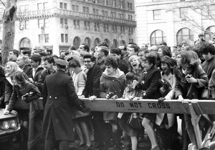 FILE - This Feb. 7, 1964 file photo shows fans pushing forward in hopes of getting a view of The Beatles after their arrival for an American tour in New York. Sunday marks the 50th anniversary of The Beatles’ performance on “Ed Sullivan,” their first appearance in America. Nielsen says 45 percent of all TV sets in use at the time were tuned into the broadcast, with fans and the uninitiated alike gathered shoulder to shoulder in their living rooms. The Beatles landed on a trigger point when they hit America. It was a pop culture sonic boom spurred by talent, timing and luck that's still rattling the windows. (AP Photo, File)