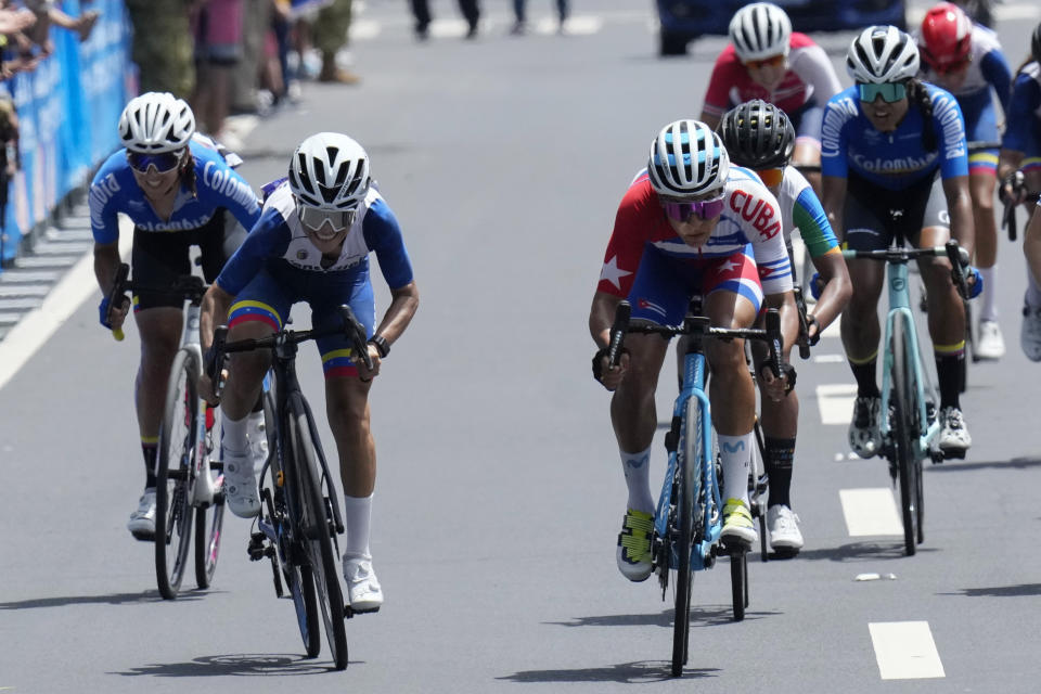 La cubana Arlenis Sierra (derecha) y la venezolana Lilibeth Chacón (izquierda) compiten en la carrera de ciclismo de ruta en San Salvador, el viernes 7 de julio de 2023, en los Juegos Centroamericanos y del Caribe (AP Foto/Arnulfo Franco)