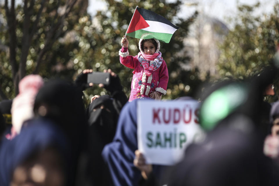 A child holds a Palstinian flag, during a rally against the proposed U.S. Mideast peace plan following Friday's Muslim prayers outside Fatih mosque in Istanbul, Friday, Jan. 31, 2020. U.S. President Donald Trump's Mideast plan would create a disjointed Palestinian state with a capital on the outskirts of east Jerusalem, beyond the separation barrier built by Israel. The rest of the Jerusalem, including the Old City, would remain Israel's capital. (AP Photo/Emrah Gurel)