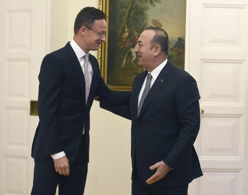 Hungarian Minister of Foreign Affairs and Trade Peter Szijjarto, left, welcomes Turkish Foreign Minister Mevlut Cavusoglu at the Ministry of Foreign Affairs and Trade in Budapest, Hungary, Friday, May 3, 2019. (Noemi Bruzak/MTI via AP)