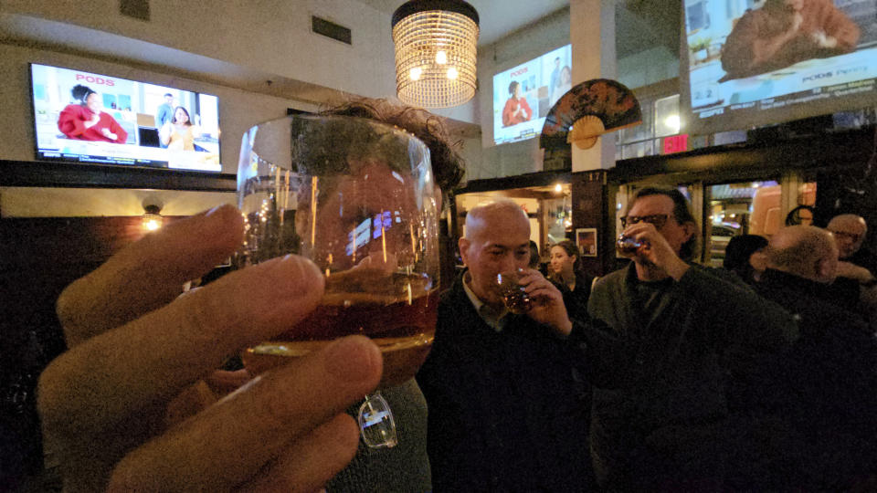 Patrons toast with whiskey at the "Far Bar," a gastropub with American and Asian food, located in the historic Far East building in the heart of Little Tokyo in Los Angeles on Saturday, March 4, 2023. Buttery, smooth, oaky. These are characteristics of the best bourbons, and a growing cult of aficionados is willing to pay an astonishing amount of money for these increasingly scarce premium spirits — and even bend or break laws. (AP Photo/Damian Dovarganes)