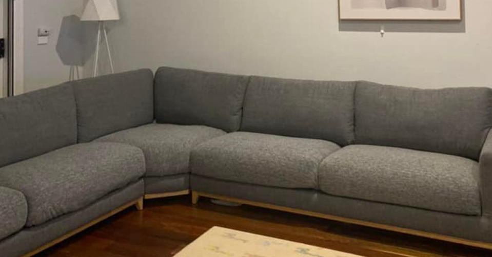 A picture of a Grey couch with a Kmart throw covering each cushion. 