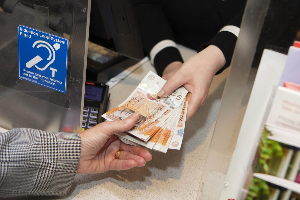 File photo dated 07/10/19 of a customer withdrawing cash at the Post Office branch as Friday is set to be the busiest day of the year for cash withdrawals from the Post Office, the network predicts.