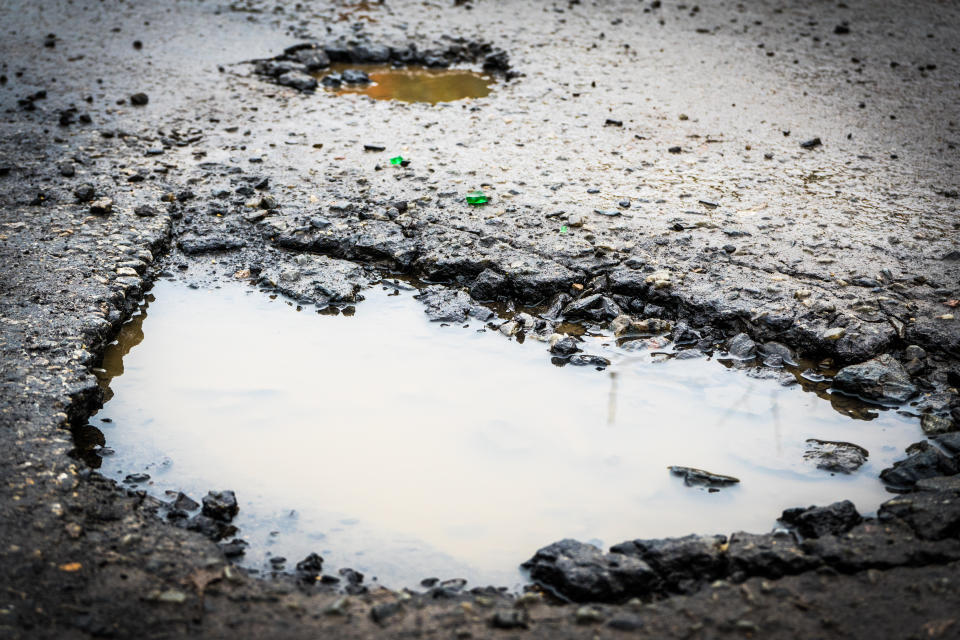 The hole in the road. Asphalt with defects. Dangerous encounter on the road. The hole in the road. Asphalt with defects. Dangerous encounter on the road.