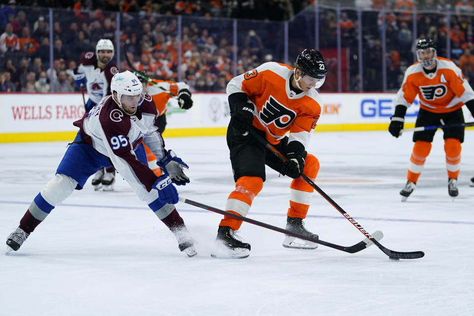 Philadelphia Flyers' Oskar Lindblom, right, tries to keep the puck away from Colorado Avalanche's Andre Burakovsky during the second period of an NHL hockey game, Monday, Dec. 6, 2021, in Philadelphia. (AP Photo/Matt Slocum)