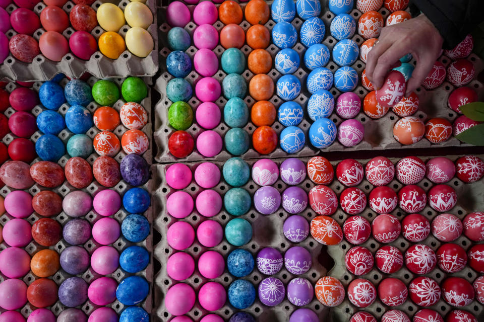 A vendor shows hand decorated Easter eggs, on Orthodox Good Friday at a green market in Belgrade, Serbia, Friday, May 3, 2024. (AP Photo/Darko Vojinovic)