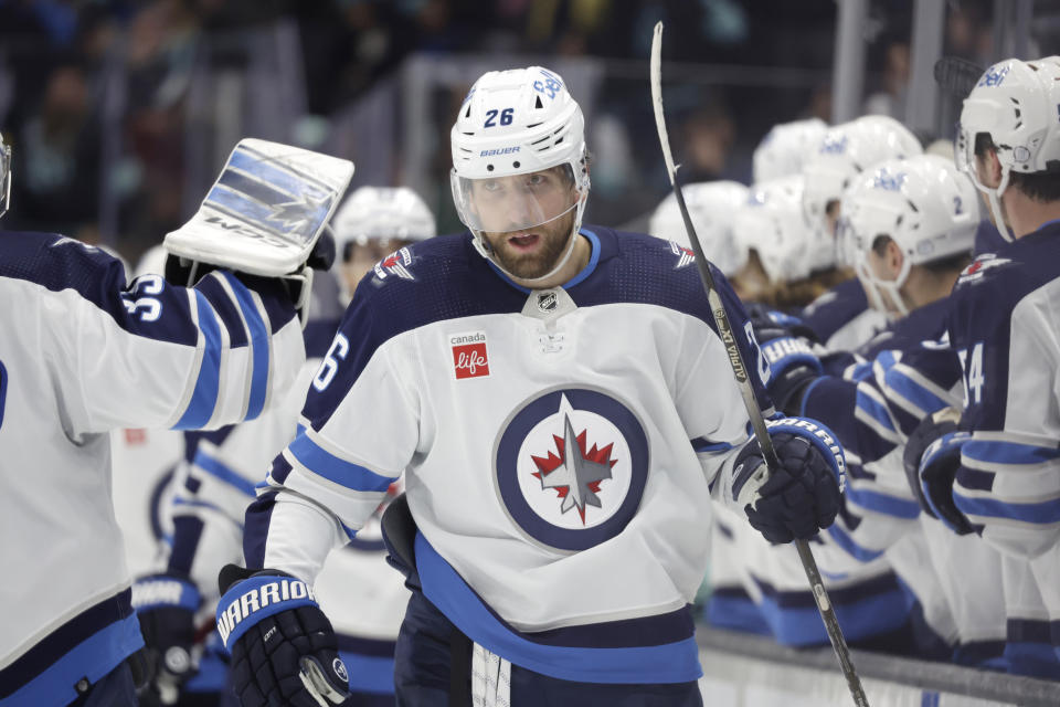 Winnipeg Jets right wing Blake Wheeler (26) is congratulated after scoring against the Seattle Kraken during the third period of an NHL hockey game to tie the game, Sunday, Nov. 13, 2022, in Seattle. (AP Photo/John Froschauer)